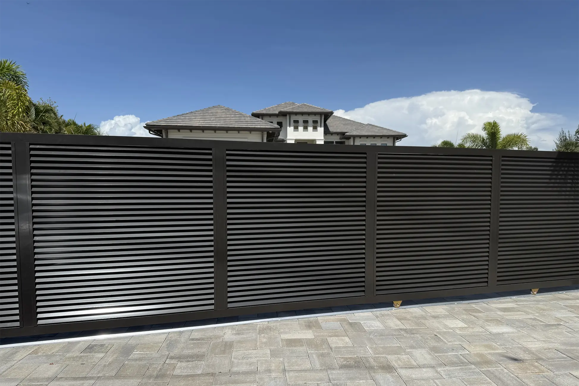 Custom louvered aluminum driveway gate installed by Grace Fence